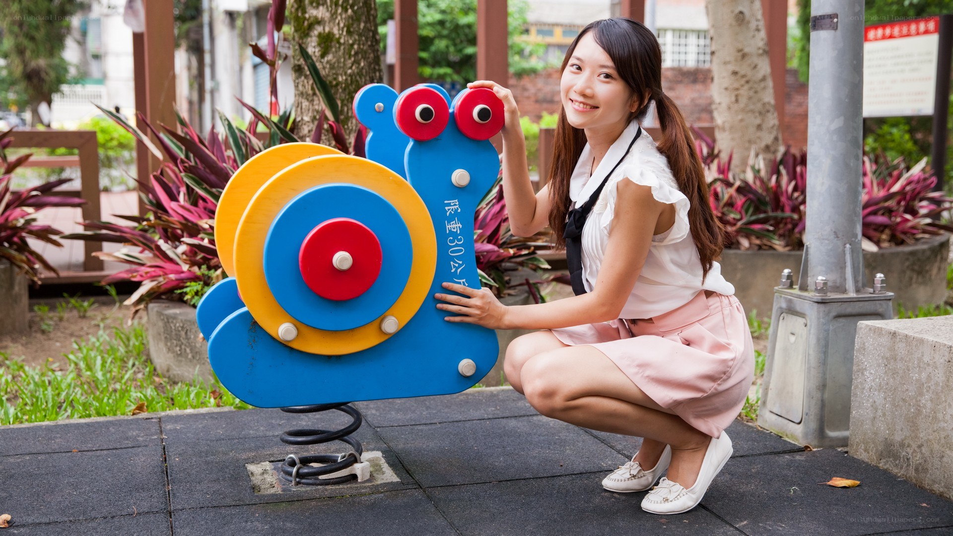 Woman posing with snail playground toy