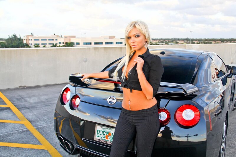 woman posing with sports car