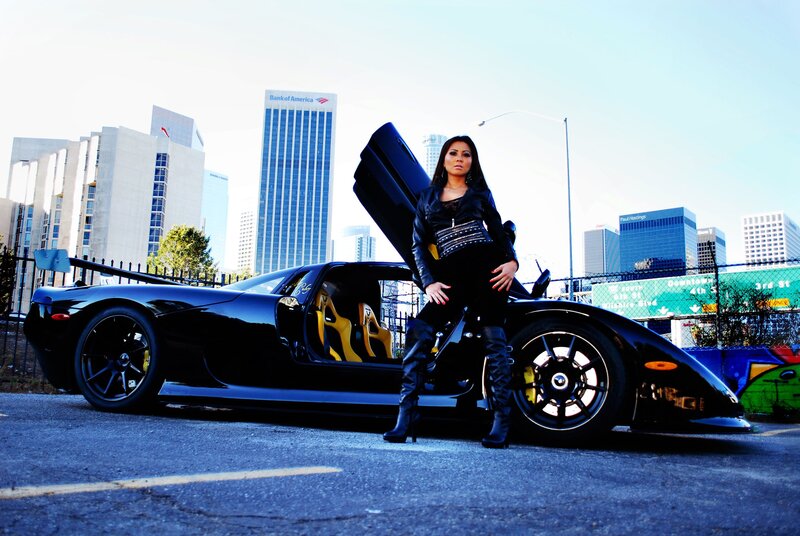 woman posing with sports car