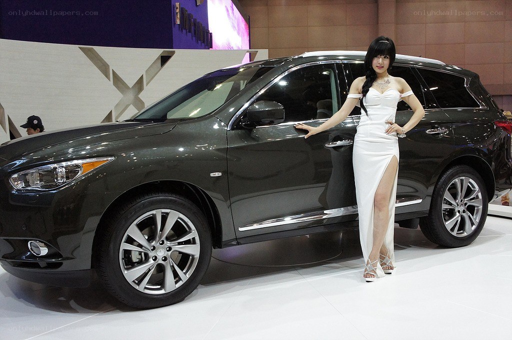 Woman posing with SUV at auto show
