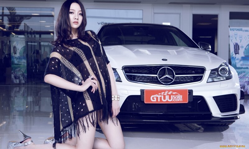 Woman posing with white Mercedes