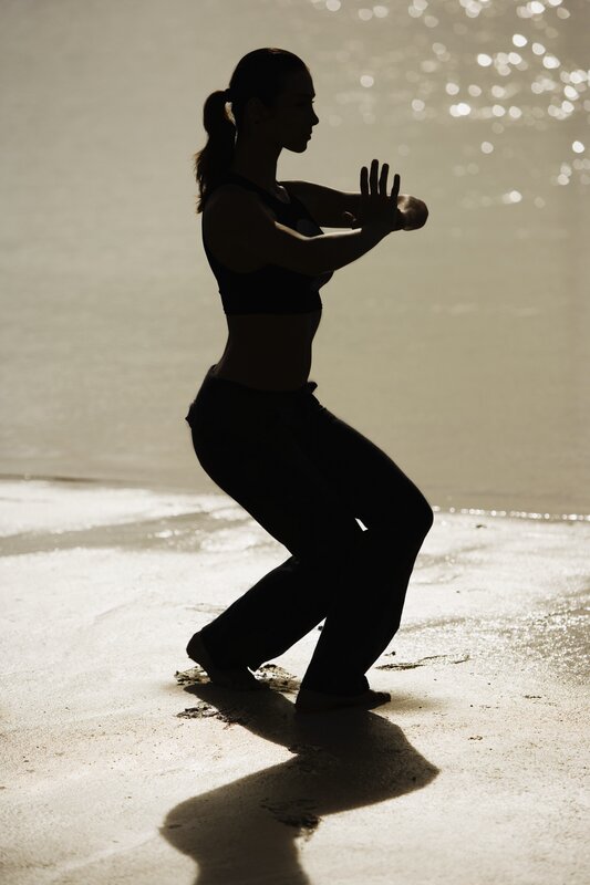 woman practicing martial arts on beach