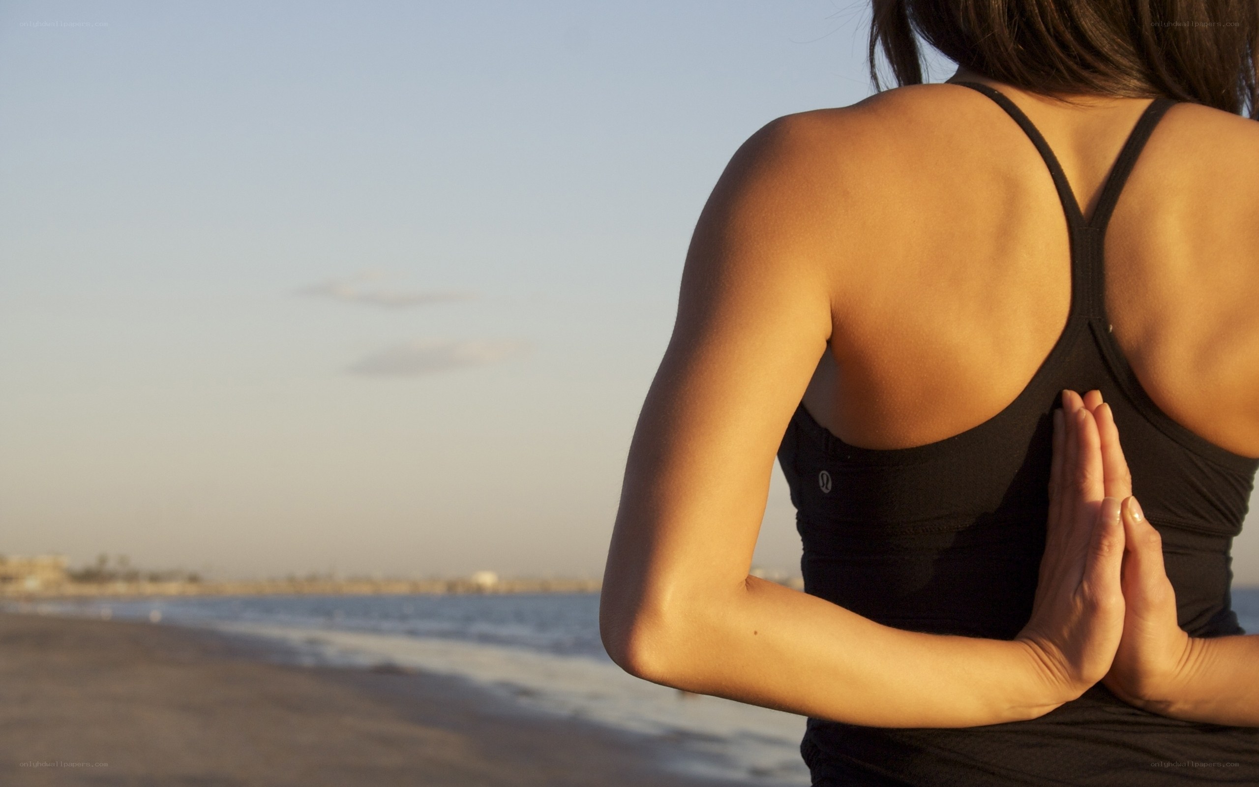 woman practicing yoga on beach