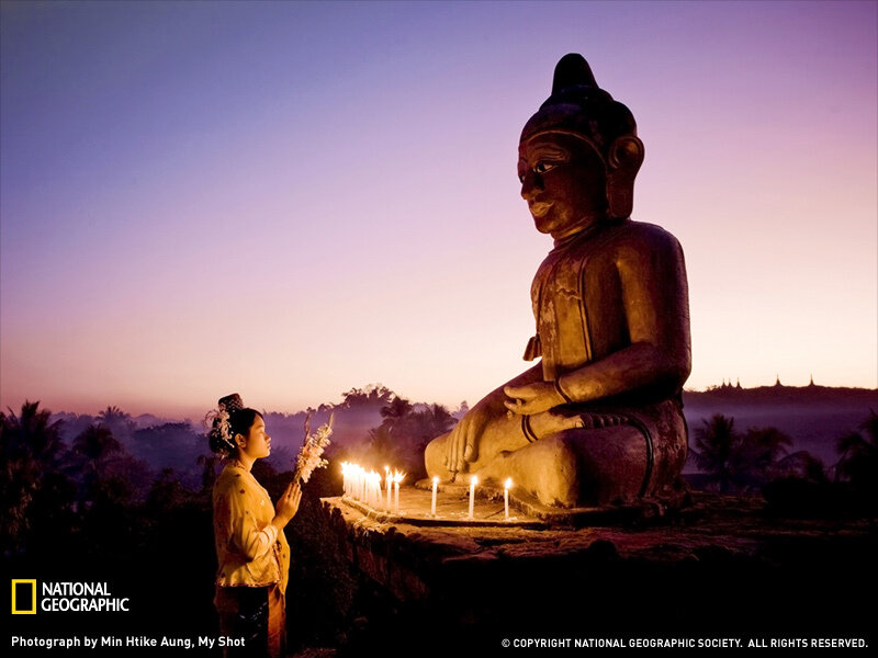 Woman praying at Buddha statue