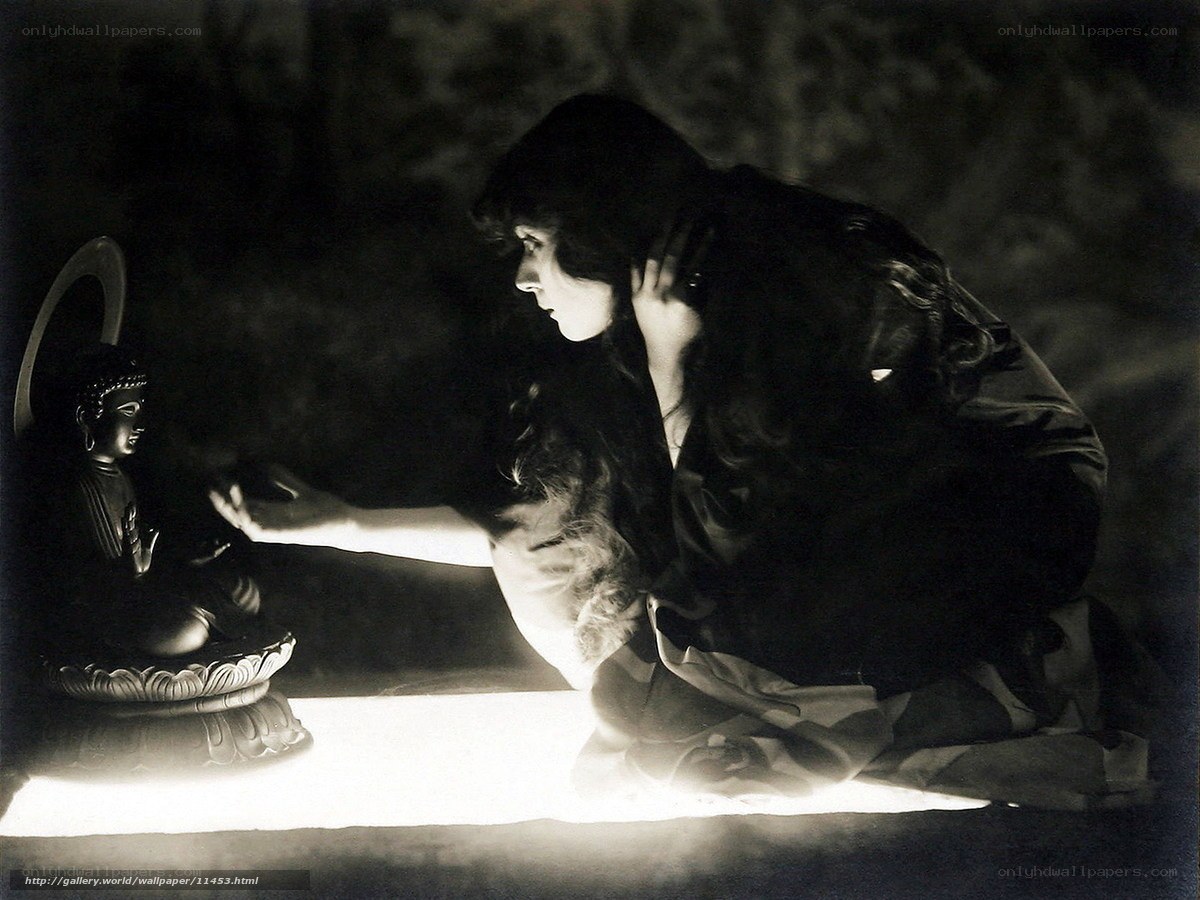 Woman praying before Buddha statue