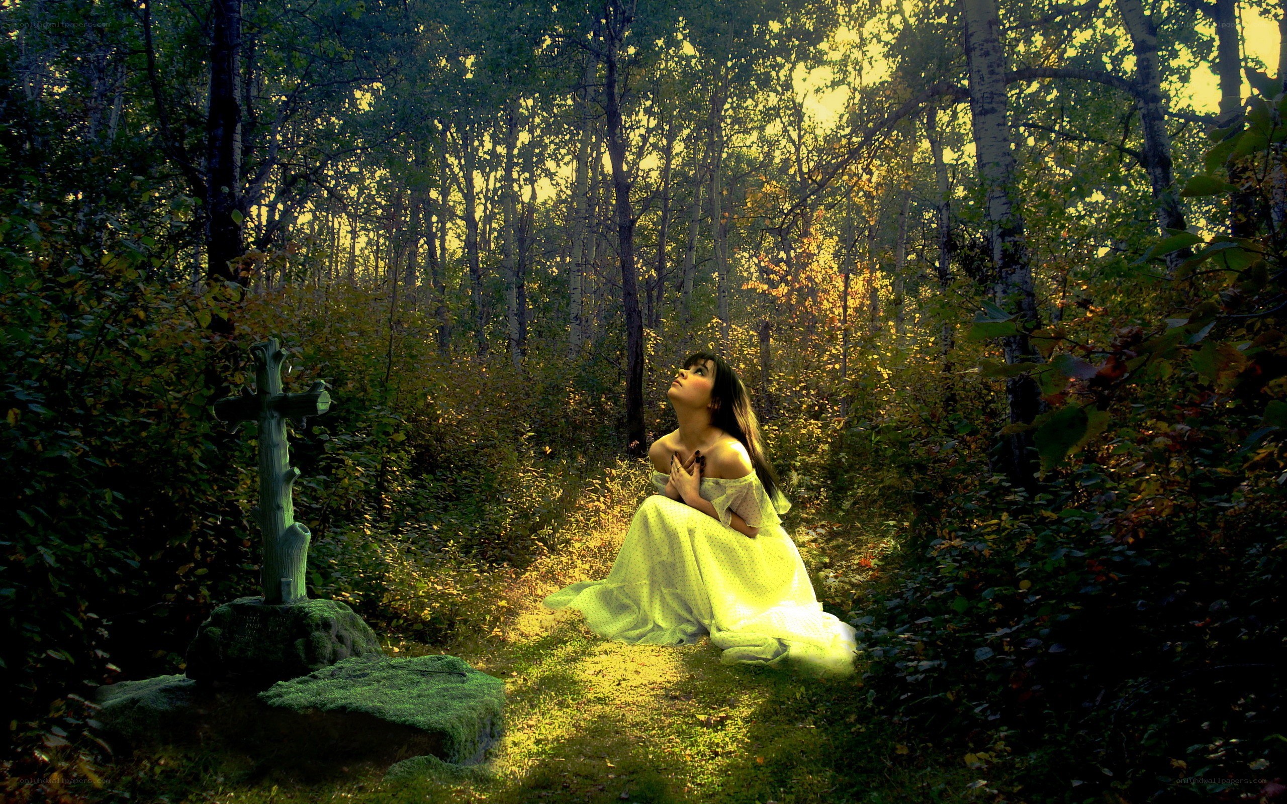 Woman praying in forest