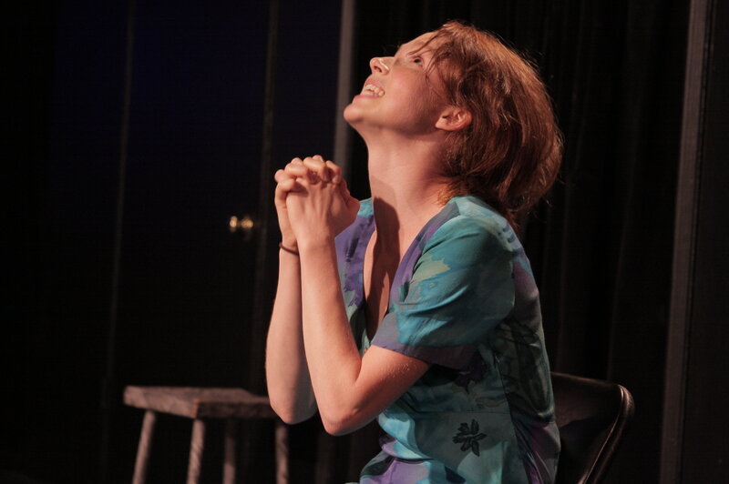 woman praying on stage