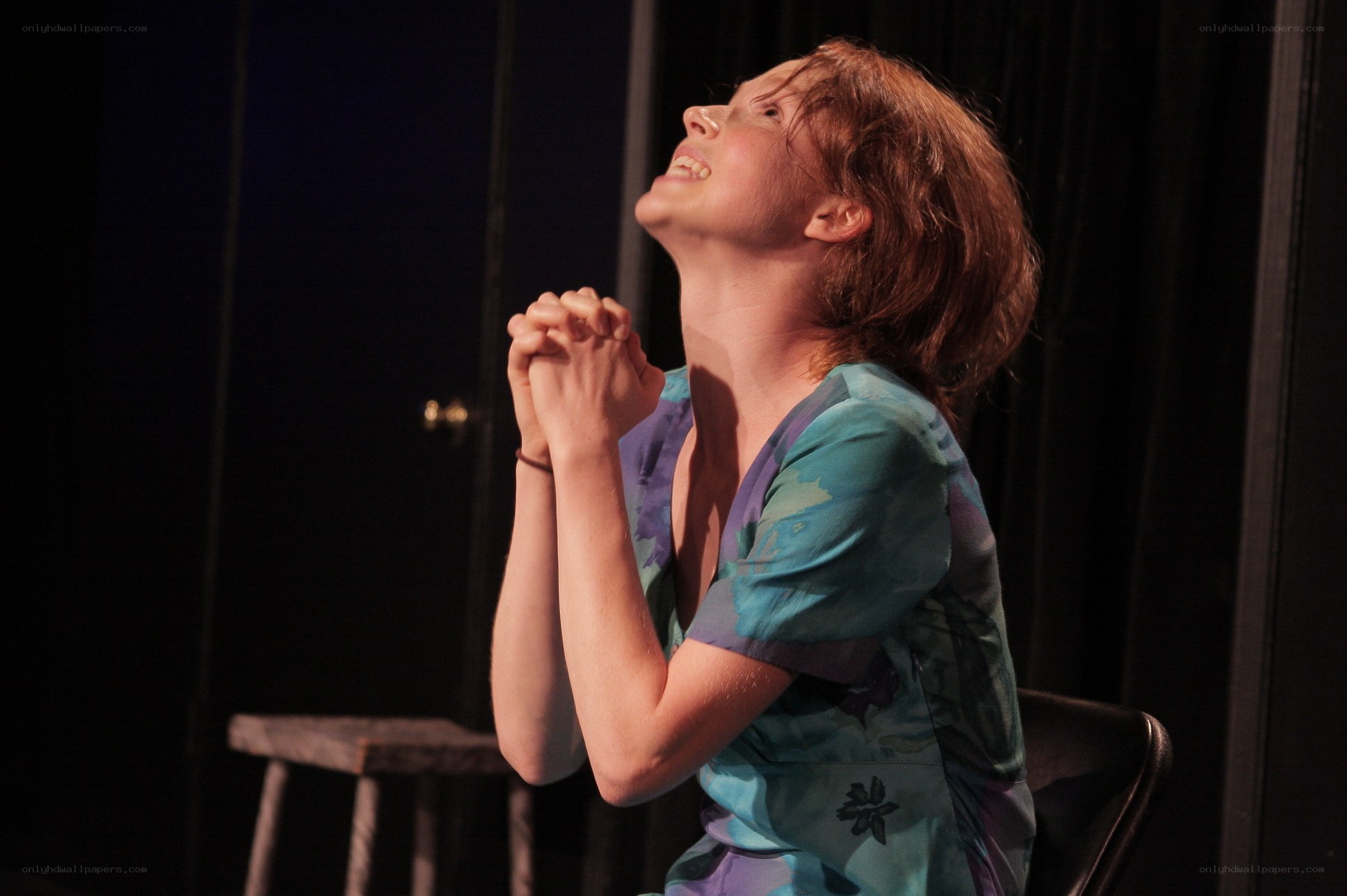 woman praying on stage