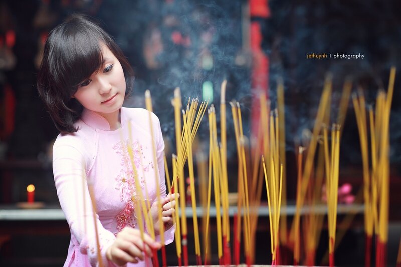 woman praying with incense sticks
