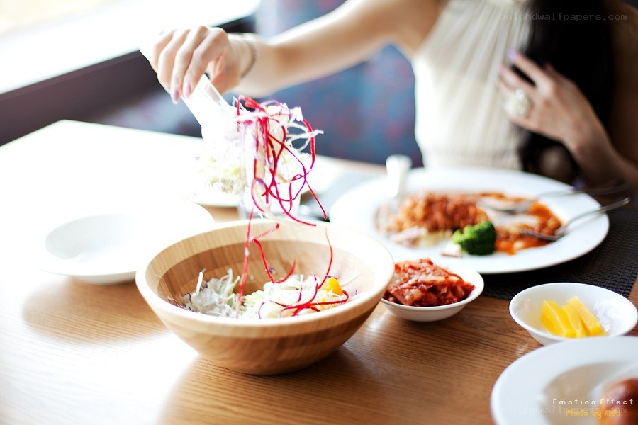 woman preparing salad at table