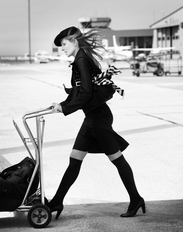 woman pulling luggage at airport