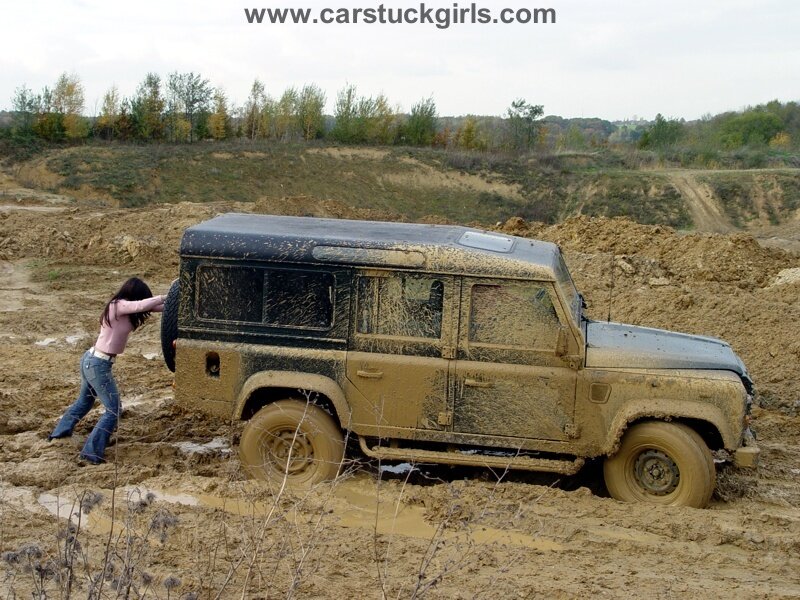 Woman Pushing Muddy Vehicle