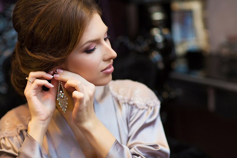 Woman Putting on Earring — Brown