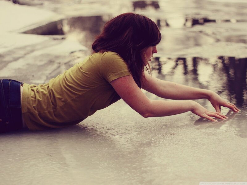 woman reaching into water