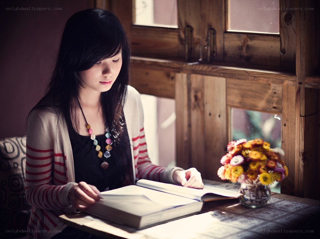woman reading book by window