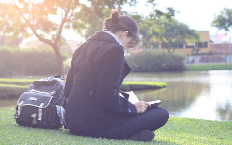 Woman Reading Book — Green, Serene, Afternoon, Photograph, Backpack