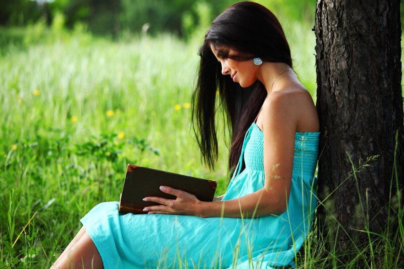 Woman reading book in a field