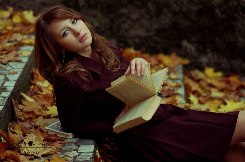 woman reading book in autumn