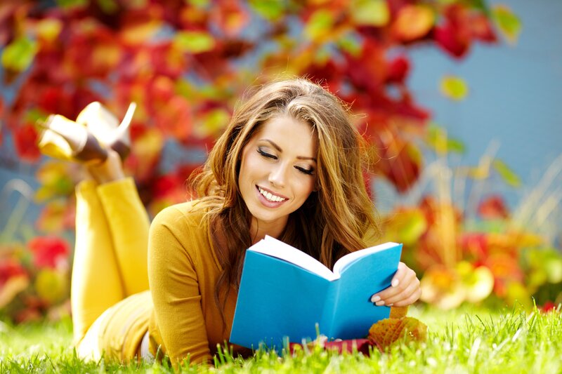 Woman reading book in autumn
