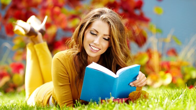 woman reading book in autumn
