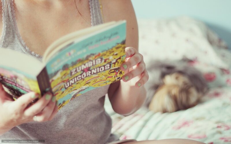 woman reading book in bed