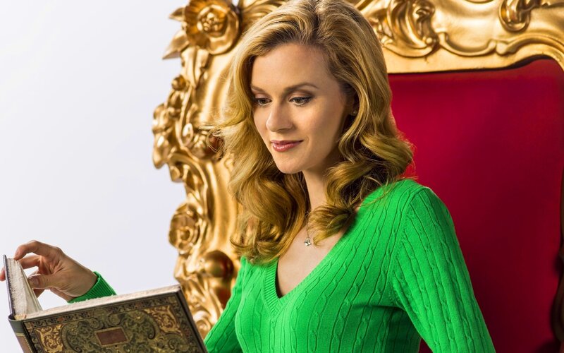 woman reading book in green sweater