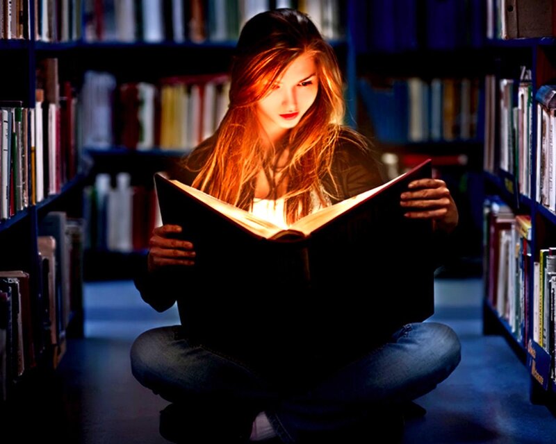 woman reading book in library