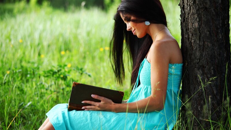 woman reading book in park