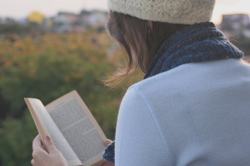 woman reading book outdoors