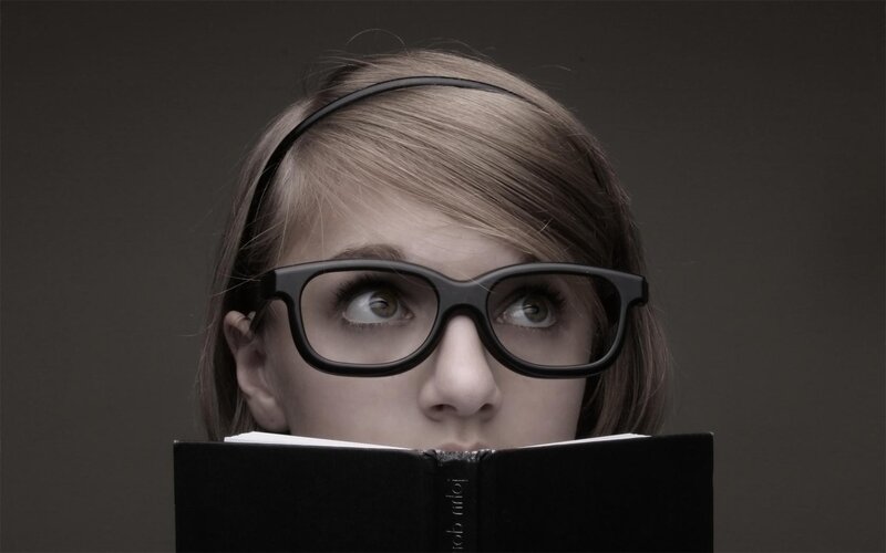 woman reading book with glasses