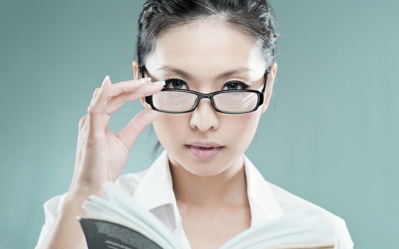 woman reading book with glasses