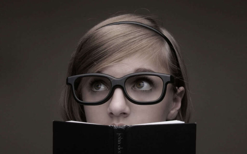 woman reading book with glasses
