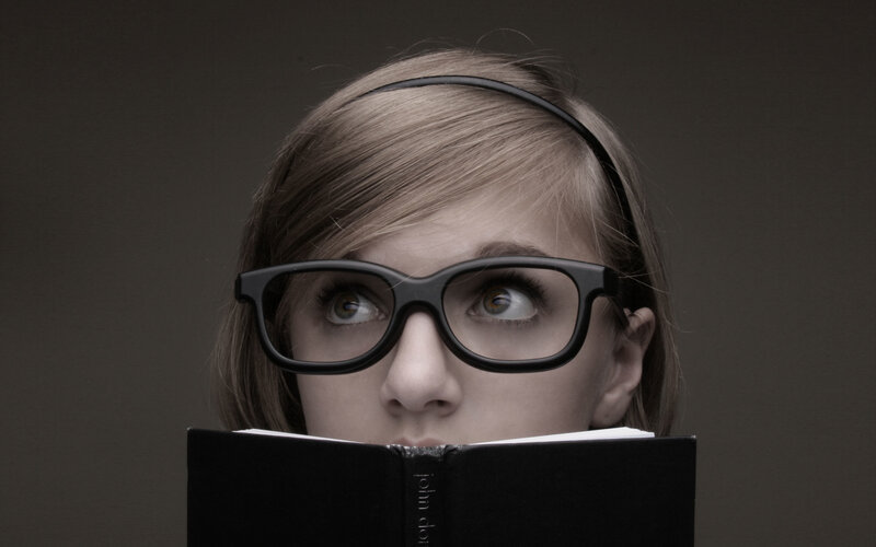 woman reading book with glasses