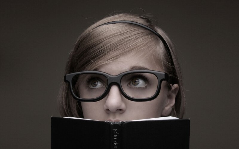 woman reading book with glasses