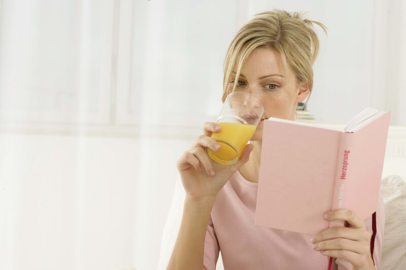 woman reading book with juice