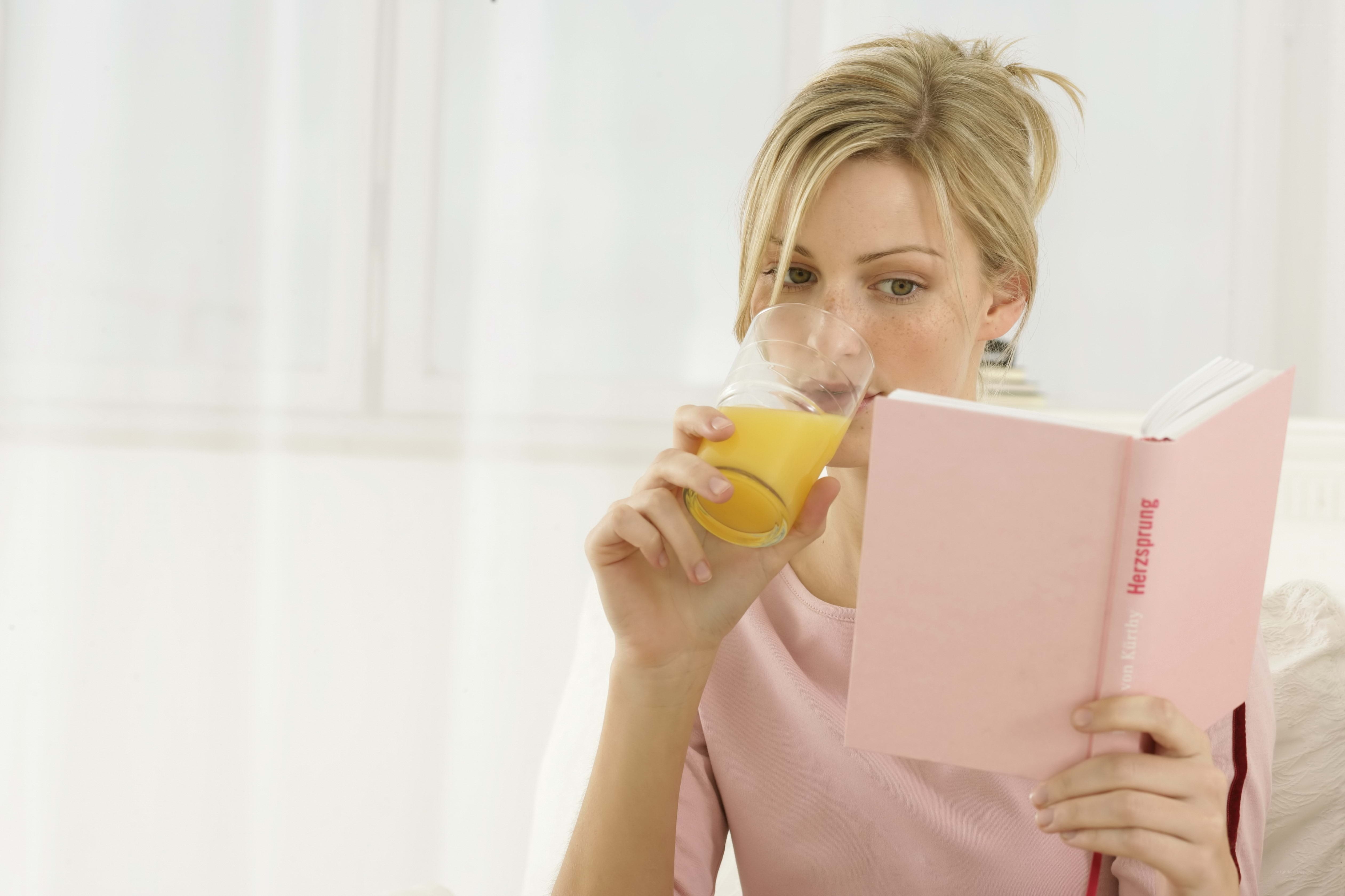 woman reading book with juice