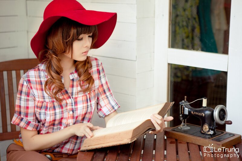 woman reading book with sewing machine