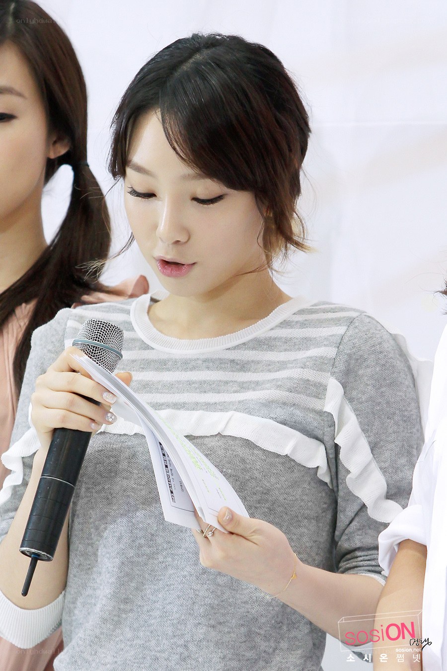 woman reading from paper with microphone