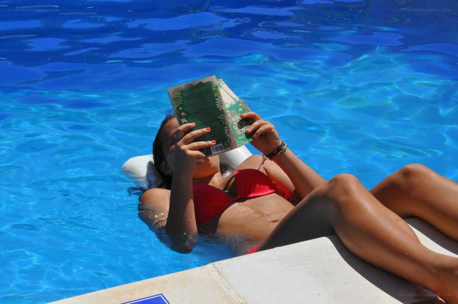 Woman reading in a pool