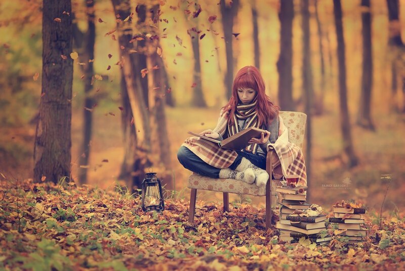 Woman reading in autumn forest