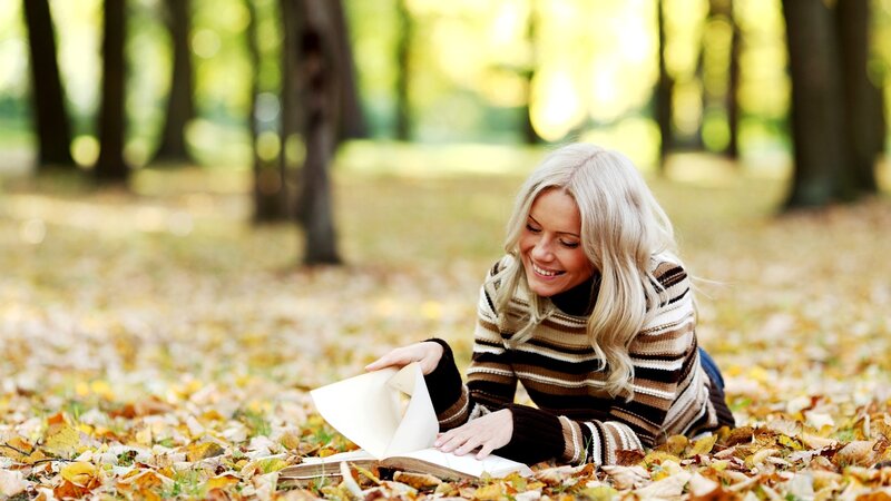 Woman reading in autumn park