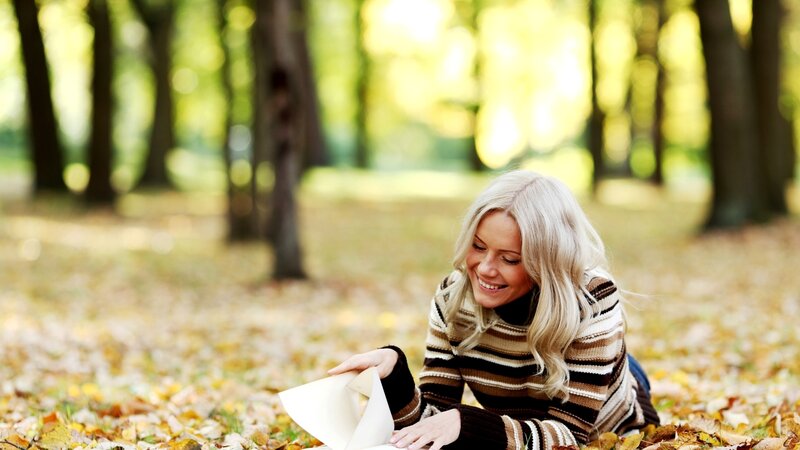 Woman reading in autumn park