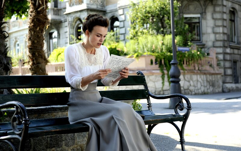 Woman reading letter on bench