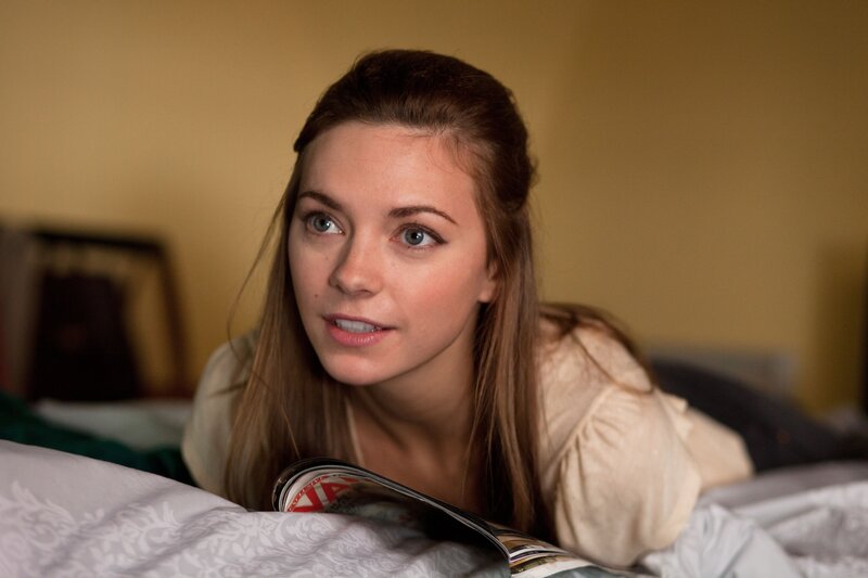 woman reading magazine in bed