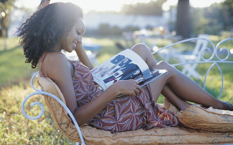woman reading magazine outdoors