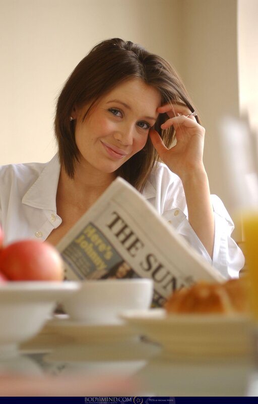 Woman reading newspaper at breakfast