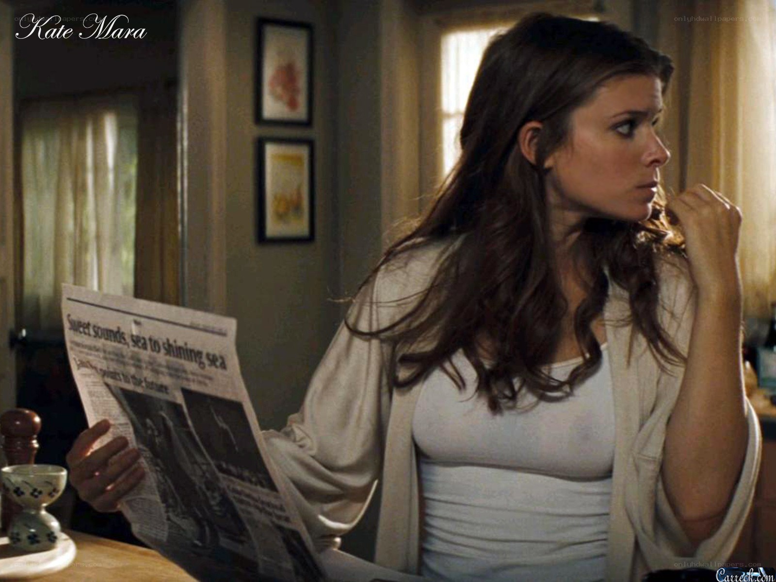 woman reading newspaper at table
