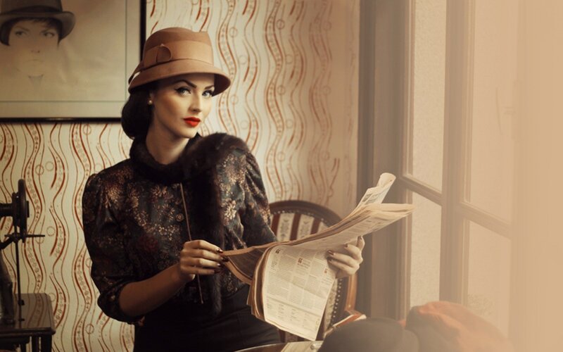 woman reading newspaper in vintage setting