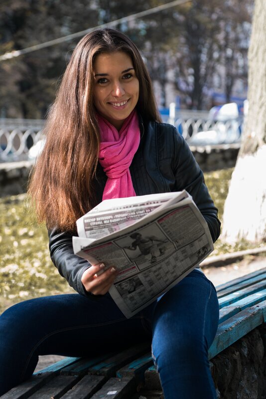 woman reading newspaper outdoors