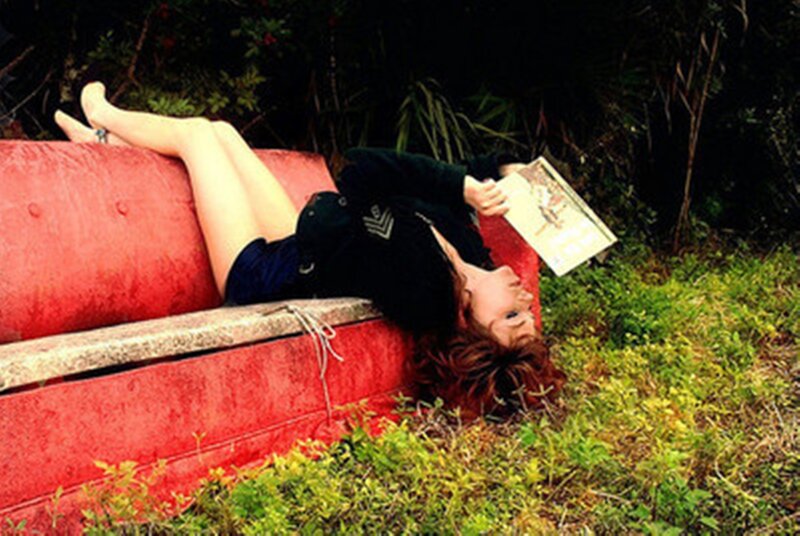 Woman Reading on Red Couch
